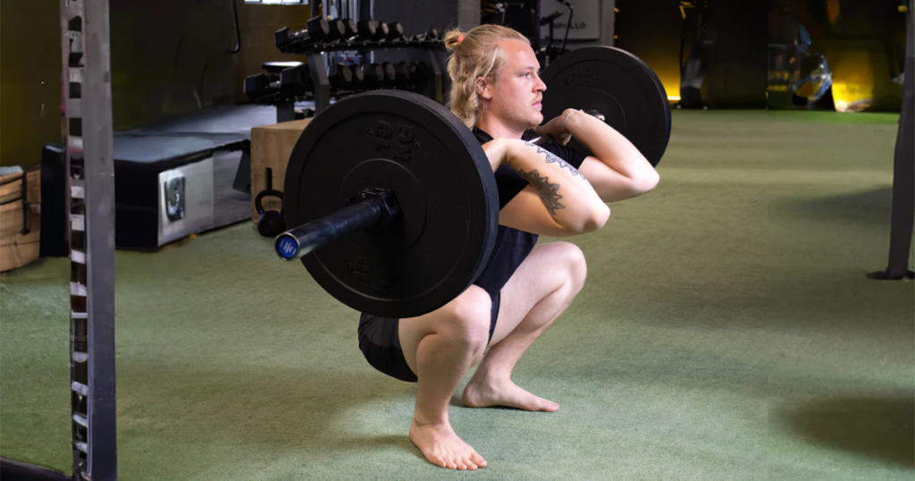 Man demonstrating an deep barbell squat variation